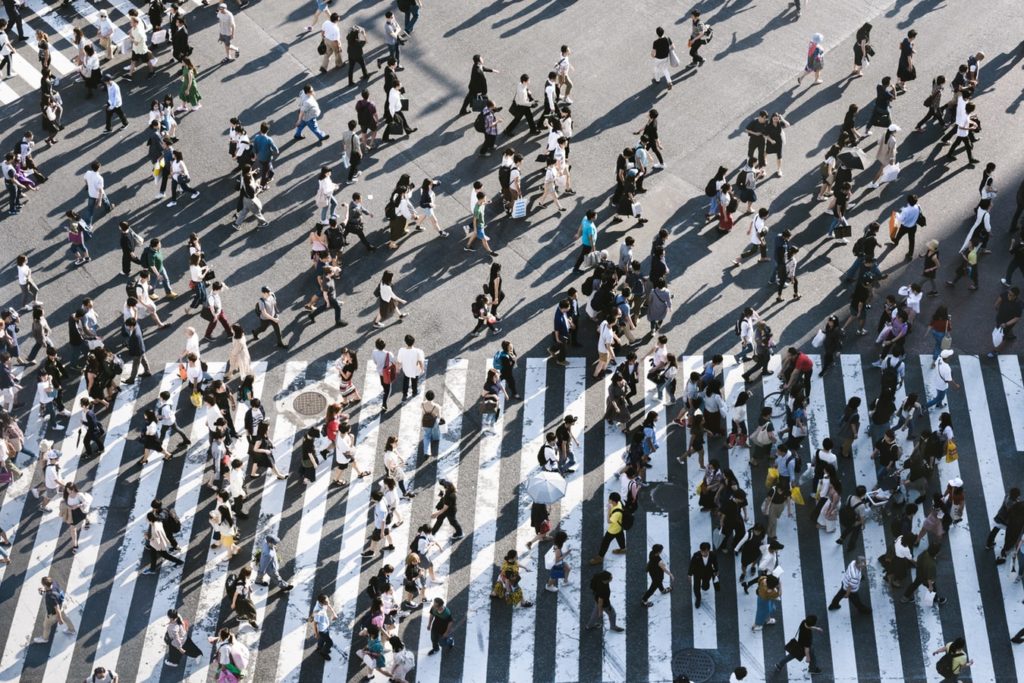 A bird's eye view of a crowd of people crossing a road